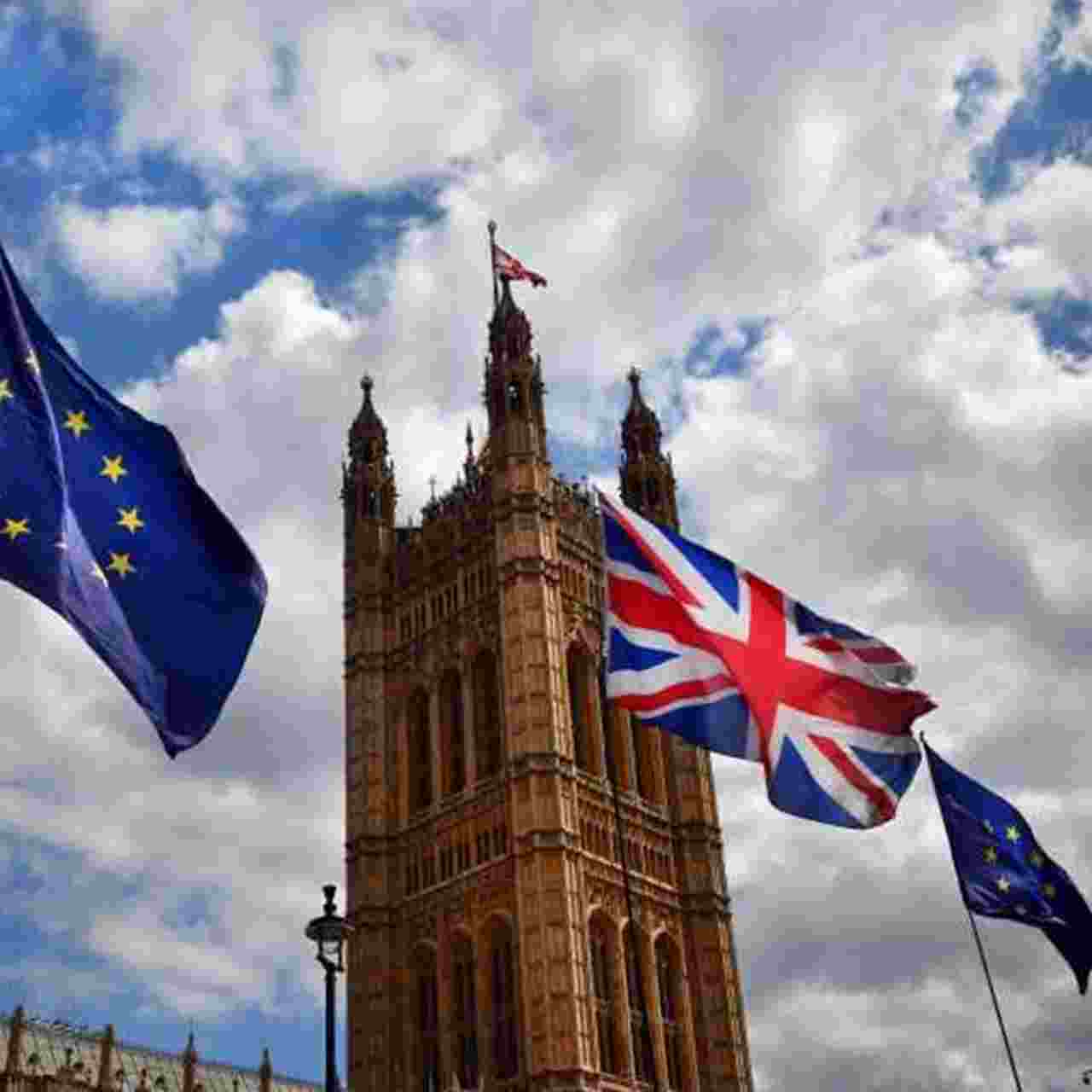 European Union and Union Jack flags flying in front of the Houses of Parliament in London