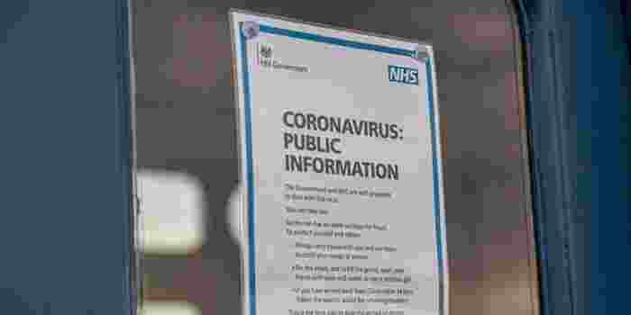 An A4 print out displayed in a door window with NHS information about coronavirus