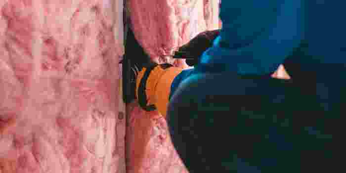 Worker installing wall insulation